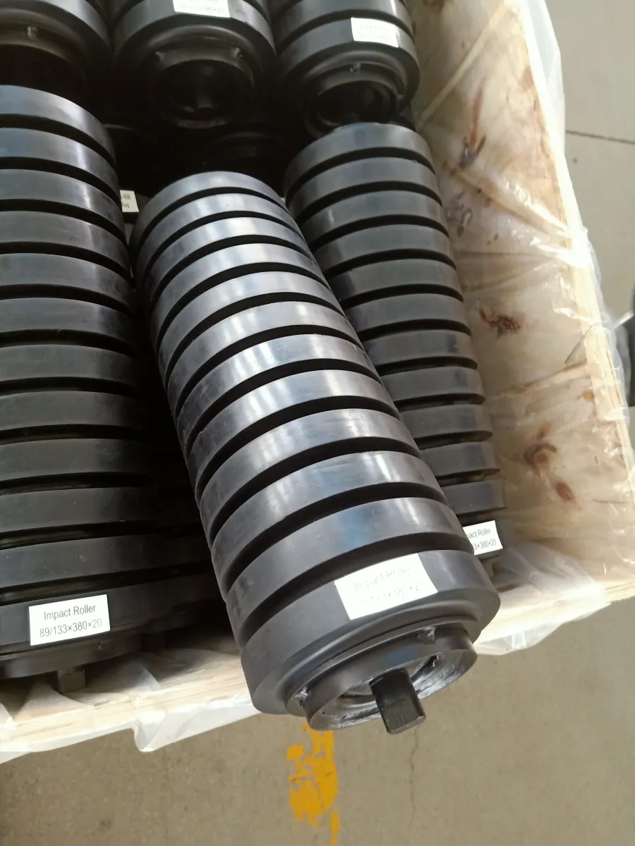 Close view of rubber-ring impact idlers and shaft ends inside a crate